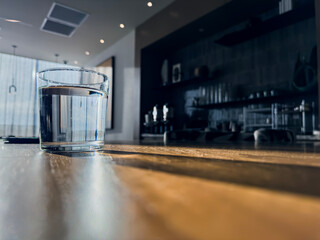 A glass of water on the table. Natural sunlight shines from behind.