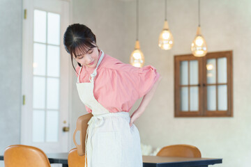 腰痛の女性飲食店スタッフ