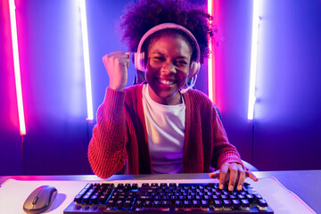 Gaming streamer, African girl playing online fighting with Esport skilled team wearing headphones...