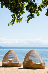 Stylish beach loungers for relaxing near the coastline, on the hotel grounds among the greenery. - obrazy, fototapety, plakaty