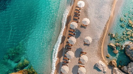 An aerial perspective showcases a breathtaking beach with umbrellas and lounge chairs near the turquoise sea, inspiring couple vacations and romantic getaways