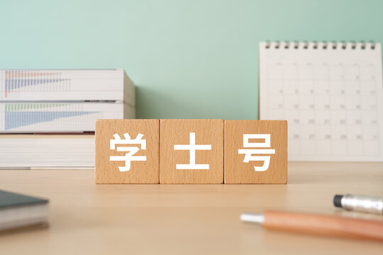 学士号の文字が入ったブロックが置かれたデスク