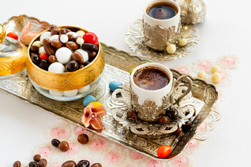 Traditional Turkish Hard Almond Candies designed in vintage stylish tray with coffee.Conceptual image