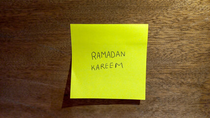 Ramadan Kareem Sticky Note on Wooden Background