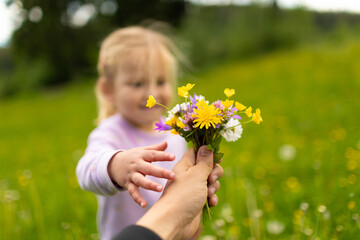 Spring is here, child with flowers in a meadow 