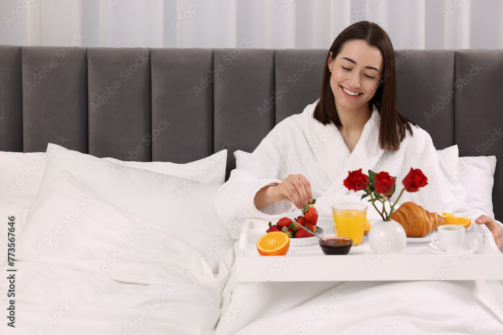 Canvas Prints Smiling woman having breakfast in bed at home, space for text