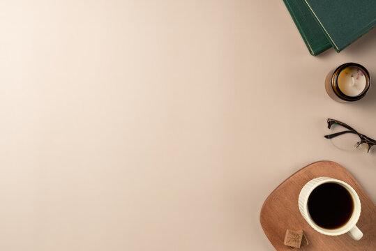 Book, glasses, candle, with cup coffee on beige background. Leisure concept, reading a book. Flat lay, top view
