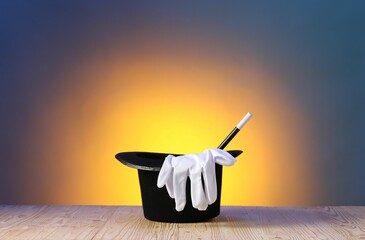 Magician's hat, wand and gloves on wooden table against color background