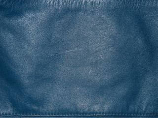 Natural leather dyed in blue with scratches macro photo as background.