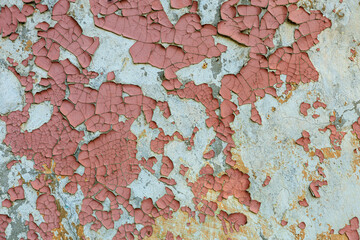 The wall is covered in peeling paint and has a lot of cracks