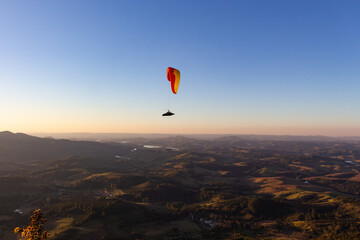 Paraglider deslizando sobre as montanhas - POÇOS DE CALDAS, MG, BRAZIL - JULY 22, 2023: Paraglider...