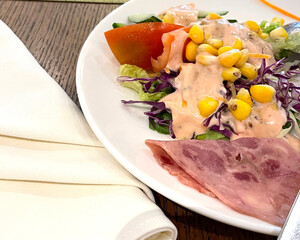 Ham salad breakfast option, ham and fresh summer salad on white plate, on wooden table, view from above