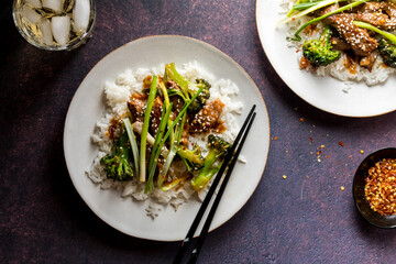 Top down view of plates of Mongolian beef on rice, ready for eating.