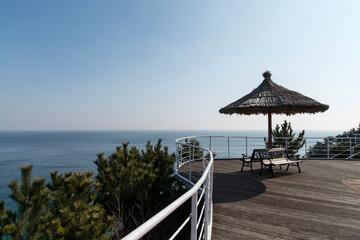 View of the straw parasol and table bench on the seaside cliff