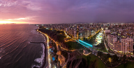 capital of peru during sunset: malecon de la reserva and its bridge with las terrazas and parque del amor during sunset light up