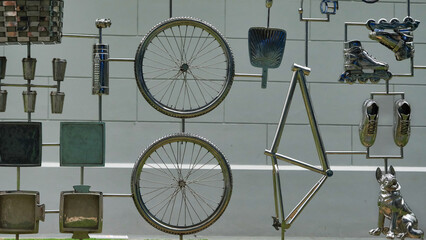 A wall of metal objects including a bicycle wheel and a dog statue