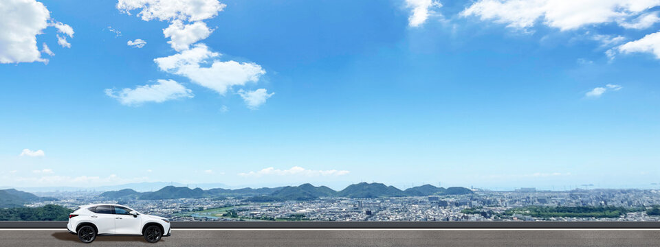 青空と街並みを背景に車でドライブ