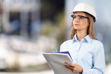 Mature professional worker at construction site holds clipboard