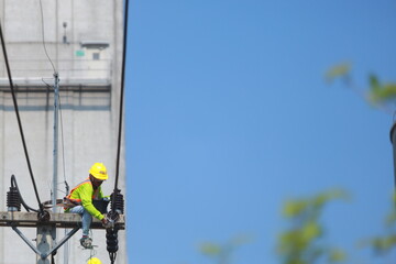 Fototapeta premium Asian man working on a power line