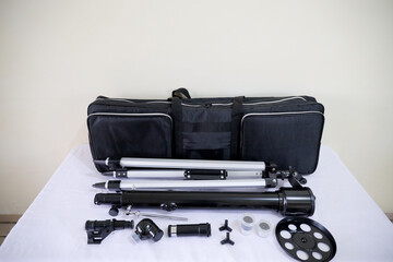 Telescope bag with accessories on white table for nature observe traveler.	
