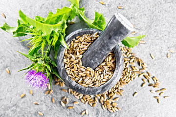 Seeds milk thistle in mortar on stone top
