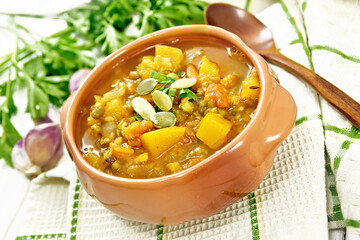 Soup-curry with pumpkin and lentils in bowl on board