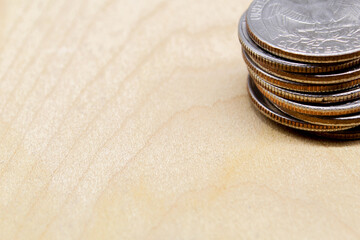 Stack of quarter coins on wooden surface with copy space