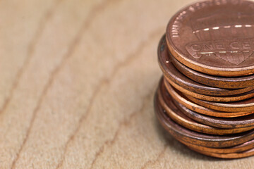 stack of one cent coins on wooden surface with copy space