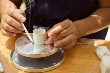 Female potter rolling clay slab
