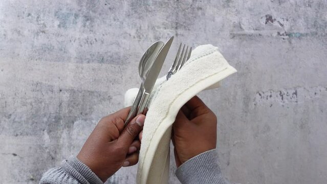  person hand cleaning and drying cutlery with a towel