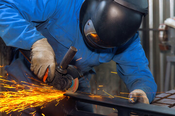 In metalworking, locksmith wears special goggles while using an angle grinder to generate sparks