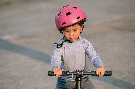 Portrait of Asian child with a pink helmet riding bike 