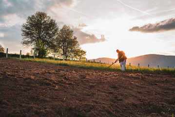 Farmer working on an agricultural fields in spring.