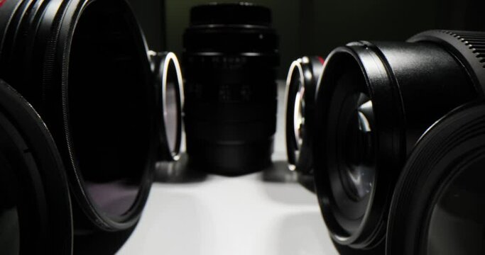 Closeup of various camera lenses on a dark background