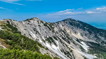 Panoramic view of mountain ridge Feistritzer Spitze (Hochpetzen), Carinthia, border Austria Slovenia. Alpine terrain of mountains Karawanks, Slovenian Austrian Alps. Hiking trail Petzen, Bleiburg