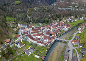 Aerial view of the small medieval town St-Ursanne on River Doubs under Jura Mountains. Saint-Ursanne was once rewarded as one of the most beautiful towns in Switzerland.