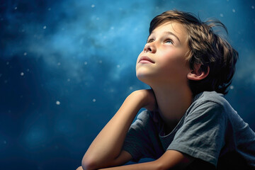 A contemplative kid model lost in thought, against a solid wall of blue background, pondering the mysteries of the cosmos with wonder and awe.