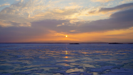 Fototapeta na wymiar Beautiful panoramic view of the frozen lake at sunset. Beauty is in nature. Winter background.