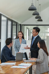 Group of business people meeting about business plans Presenting and explaining financial charts of partners from papers, graphs and data on laptop computer at office.