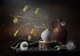 Modern still life with dried flowers in a round vase on a dark background