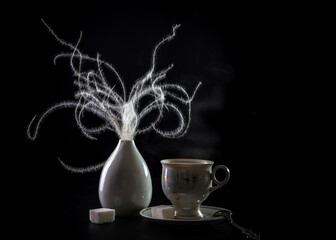 Modern still life with feather grass in a white vase and coffee in a cup on a dark background