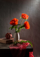 Modern still life with poppies in a clay vase and pomegranate on a dark background