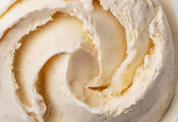 Vanilla ice cream scooped out of container
