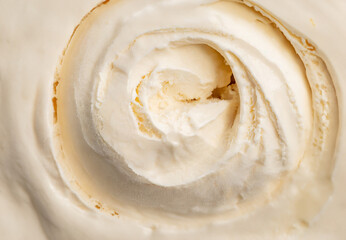 Vanilla ice cream scooped out of container
