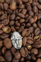 Top view on silver ring on a background of coffee beans. Handcraft precious item. Jewelry accessories.