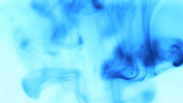Blue ink scattered in the abstract background of water
