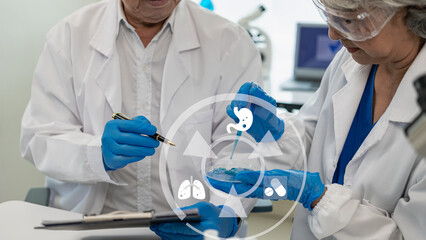 Two senior Asian men and women are scientists researching biology and chemistry. Couple wearing...