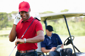 Man, phone call and check time on golf course, communication and planning for schedule. Black male...
