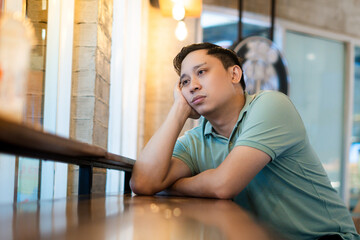 Peaceful Contemplation, young Asian man alone in a Modern Café