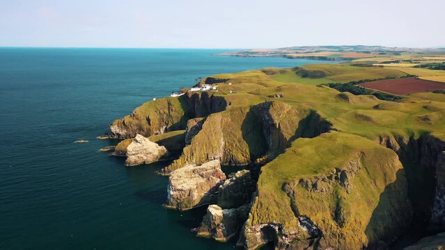 Aerial Reveal of St Abbs Head's Majestic Cliffs and Lighthouse, Scotland, United Kingdom.